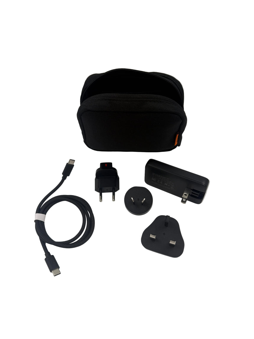 Collection of travel accessories including a black carrying case, plugs, and cables