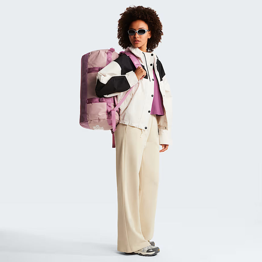 The North Face Base Camp Duffel Small 50L Metal Pink/Hushed Lavender - lifestyle shot showing versatile backpack and duffel carry options