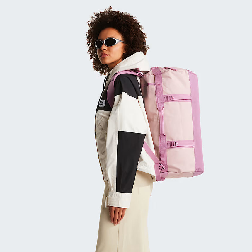 The North Face Base Camp Duffel Small Metal Pink/Hushed Lavender - side view with detachable ergonomic shoulder straps and padded handles