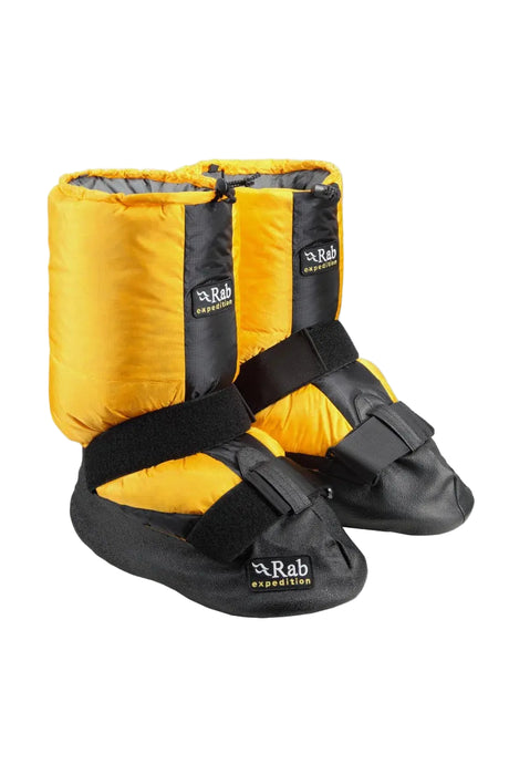 Yellow and black Rab expedition ski boots on a white background