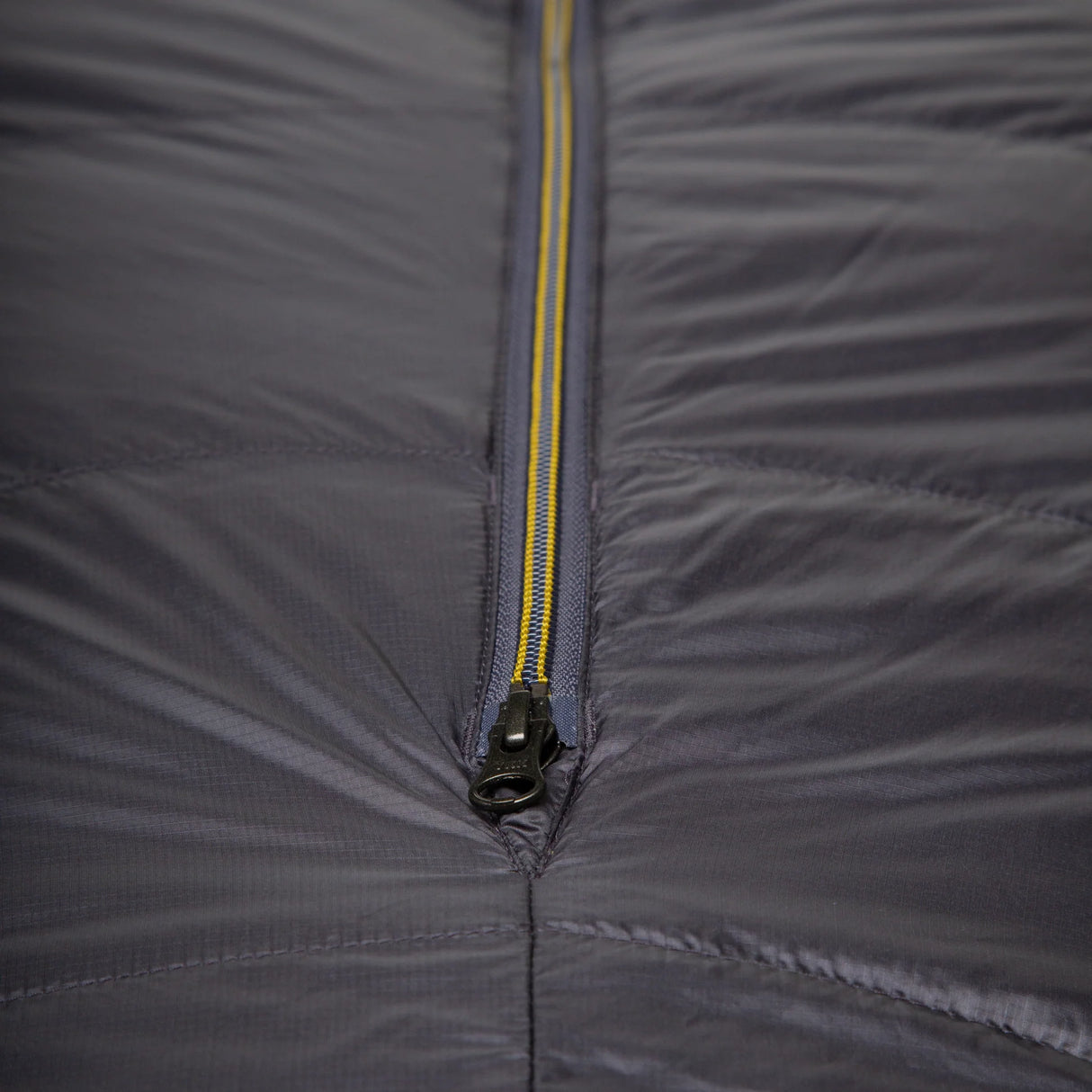 Mountain Equipment Helium GT 800 Sleeping Bag in Anvil Grey - lifestyle view showing warm roomy GT fit sleeping bag for cold-weather trekking and alpine use