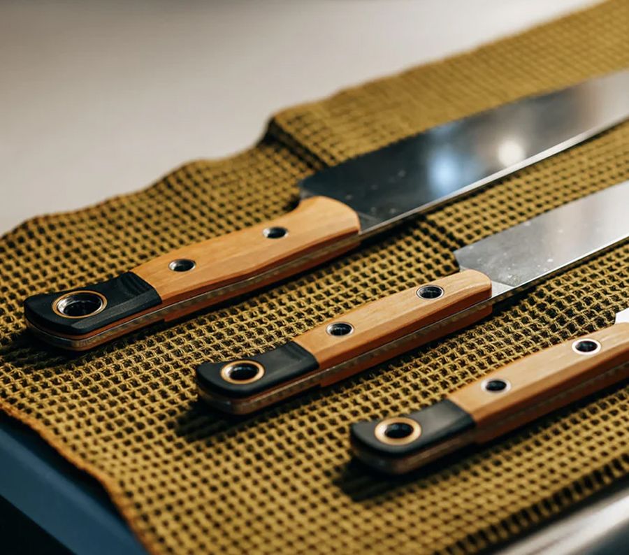 Benchmade 4000-02 three-piece kitchen knife set in Maple Valley Richlite, laid out in knife roll
