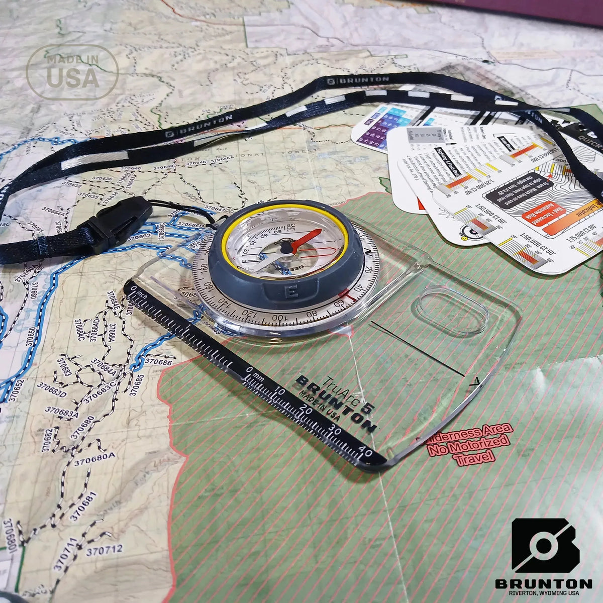 Brunton compass on a map with a lanyard and packaging