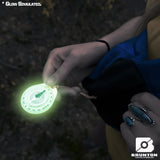 Glowing compass held by a person with a dark background