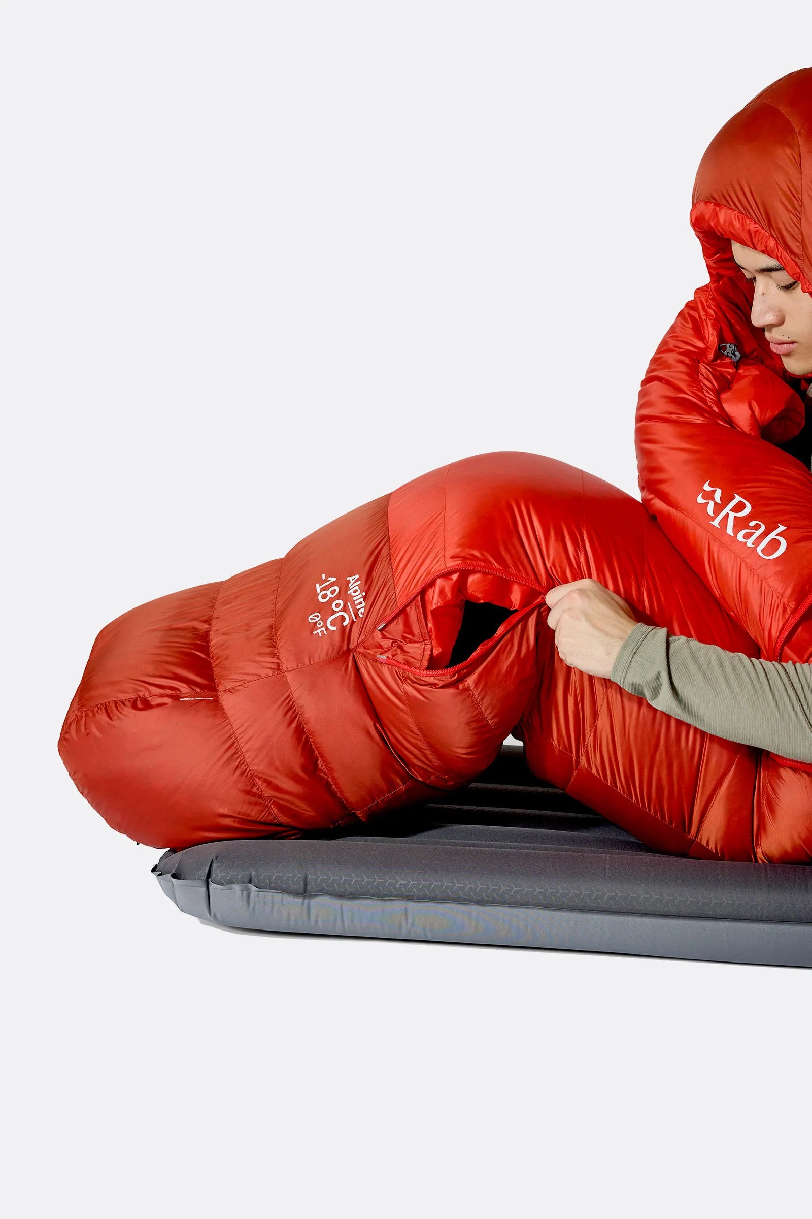 Rab Alpine Down Sleeping Bag (-18°C/0F) in Dark Horizon/Tuscan Red - Model Adjusting Zip, Seated