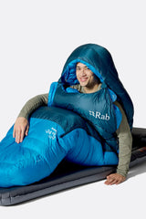 Rab Ascent Down Sleeping Bag (-24°C/-11F) in Tempest Blue/Maya Blue - Model Seated Hood