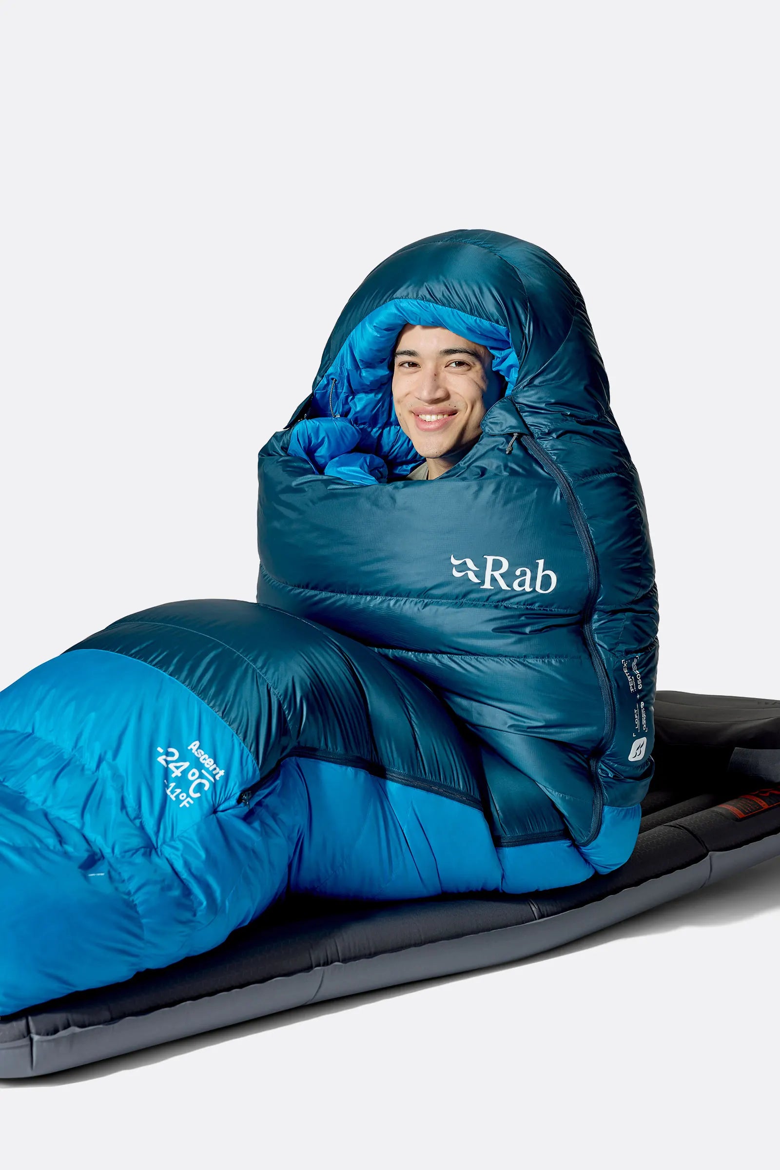 Rab Ascent Down Sleeping Bag (-6°C/21F) in Tempest Blue/Maya Blue - Model Seated Hood Close