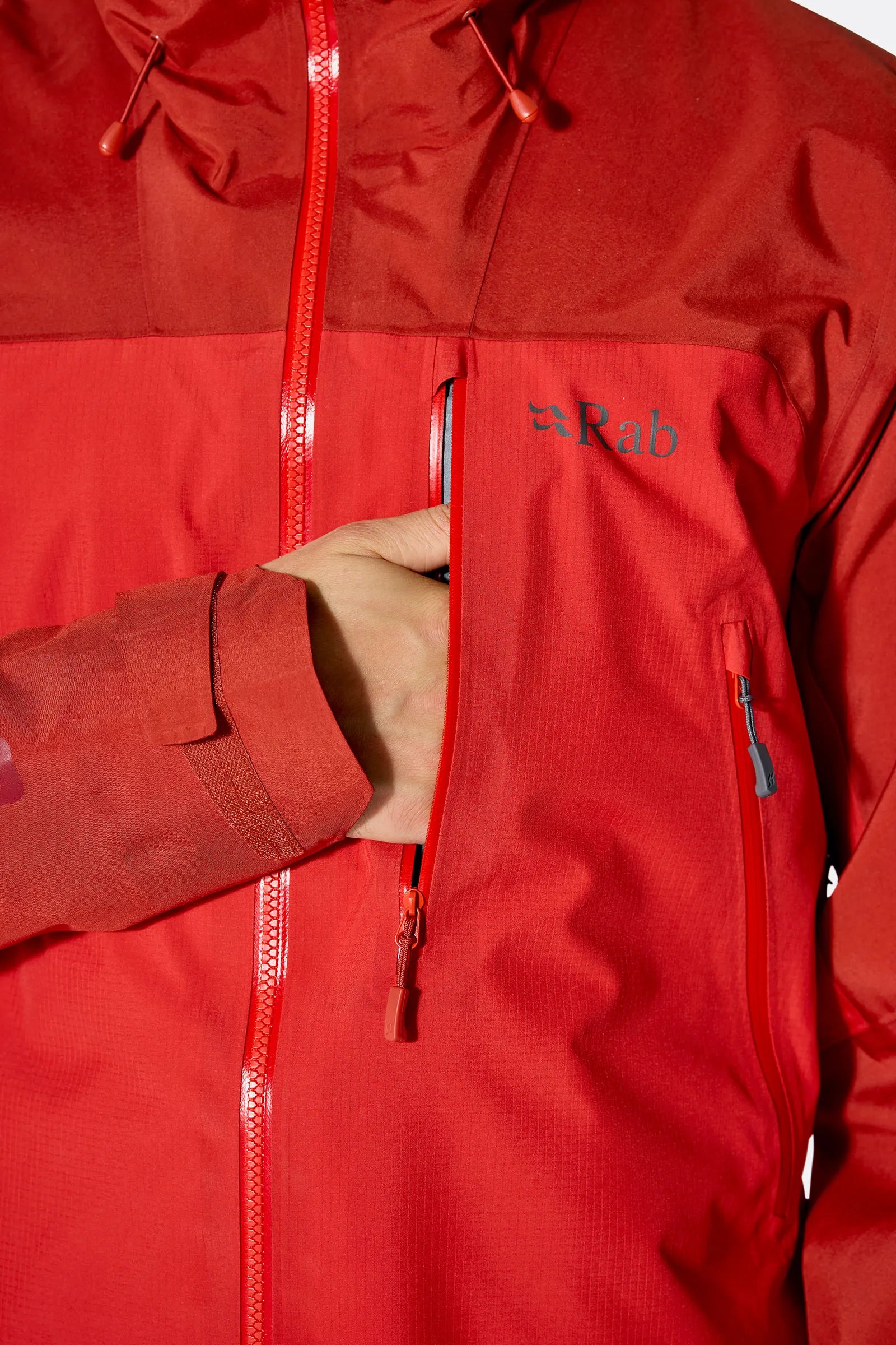 Rab Men's Latok Mountain GORE-TEX Pro Jacket in Tuscan Red/Dark Horizon (styling reference) - front zip and pocket detail, worn