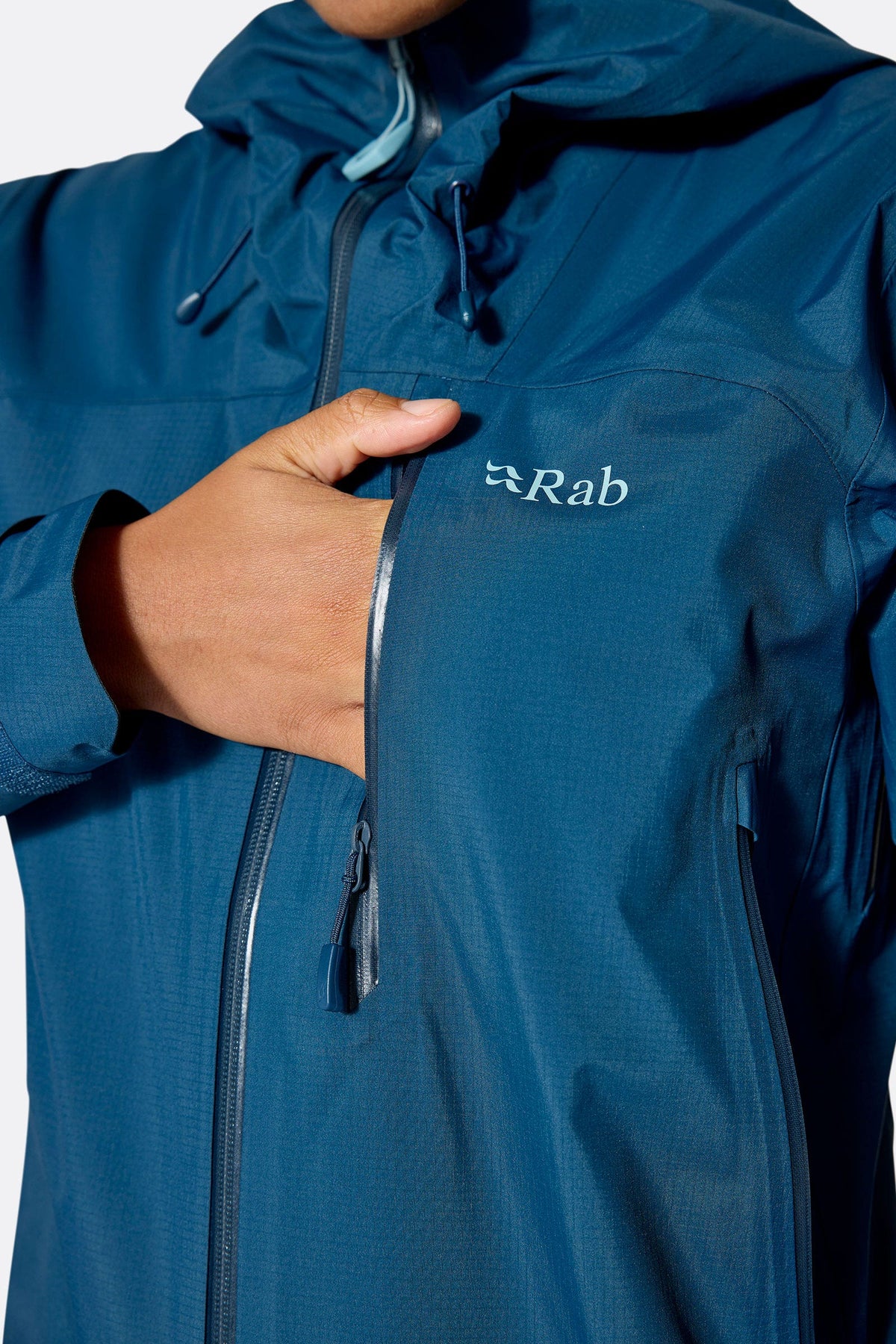 Rab Women's Firewall Mountain Waterproof Jacket in Tempest Blue - chest pocket detail, worn