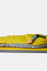 Rab Women's Neutrino Down Sleeping Bag (-6°C/20F) in Zinc/Dark Pollen - Model Lying Detail