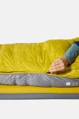 Rab Women's Neutrino Down Sleeping Bag (-6°C/20F) in Zinc/Dark Pollen - Model Lying Left