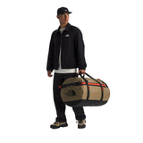 The North Face Base Camp Duffel Large Cedar/Black-Lava Red Model Holding Handle of Duffel