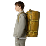 The North Face Base Camp Duffel Medium Golden Tan/Cedar - side view with detachable ergonomic shoulder straps and padded handles