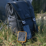 Backpack with a power bank in a grassy outdoor setting