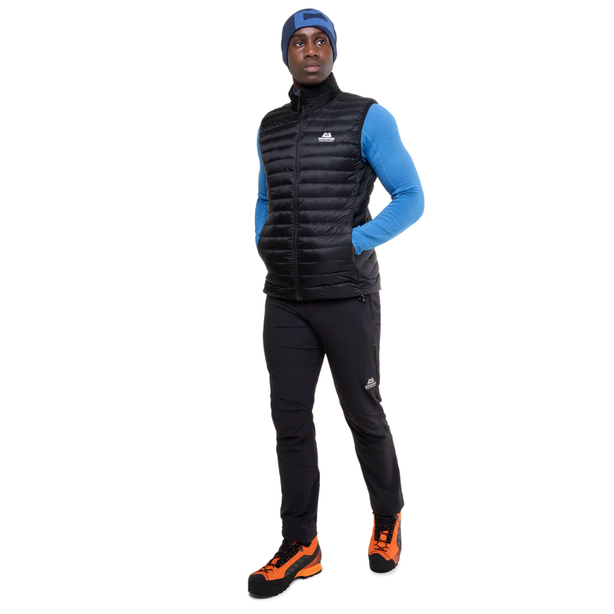 Mountain Equipment Frostline Men's Vest in Black worn on model - full length angled front view showing lightweight packable down vest for year-round layering