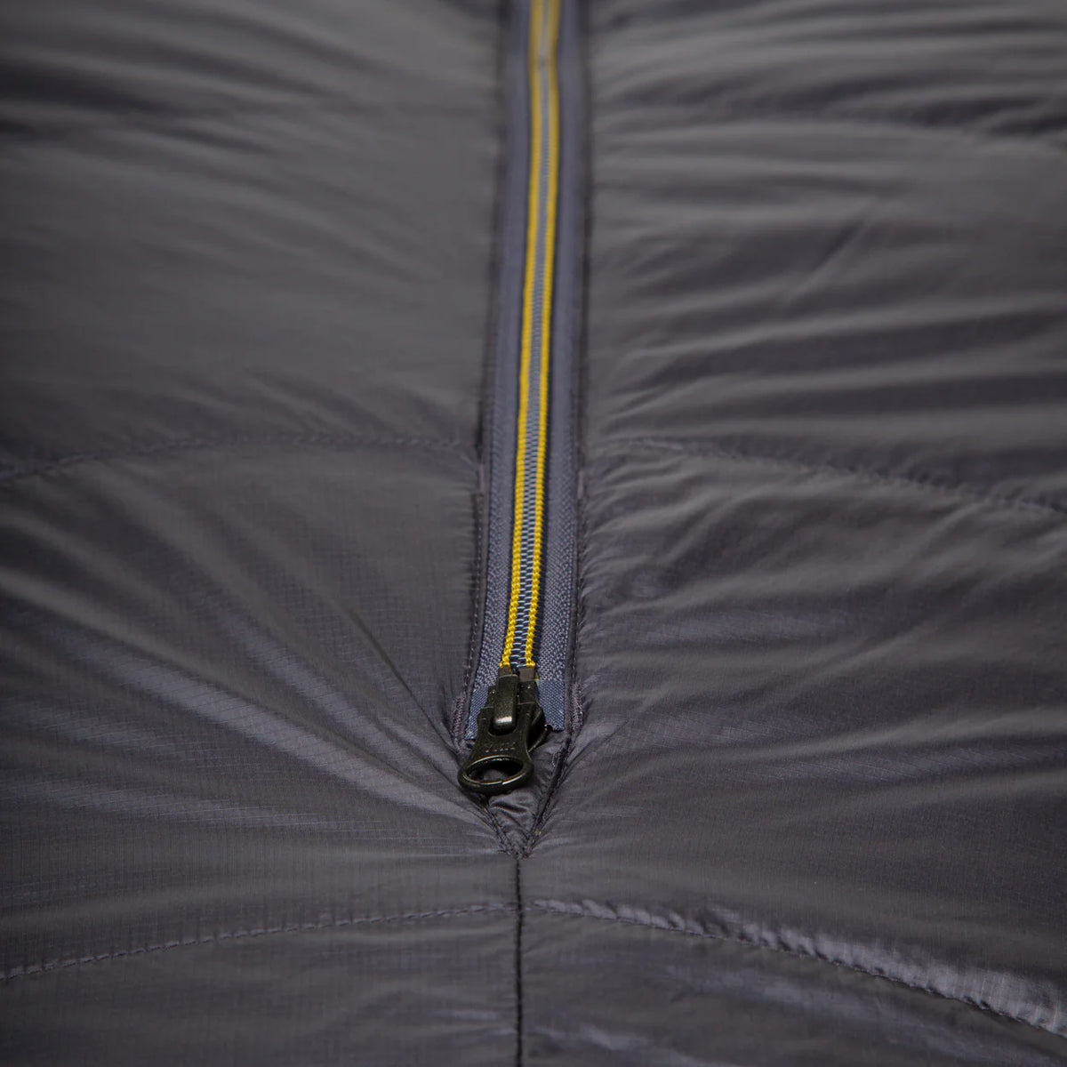Mountain Equipment Helium GT 250 Sleeping Bag in Anvil Grey packed into waterproof roll-top stuff sack showing lightweight packable construction