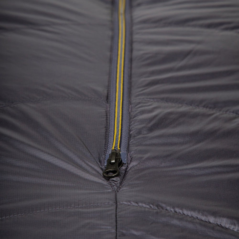Mountain Equipment Helium GT 600 Sleeping Bag in Anvil Grey packed into waterproof roll-top stuff sack showing lightweight packable construction
