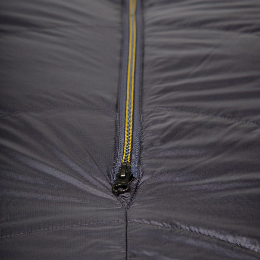 Mountain Equipment Helium GT 800 Sleeping Bag in Anvil Grey - lifestyle view showing warm roomy GT fit sleeping bag for cold-weather trekking and alpine use
