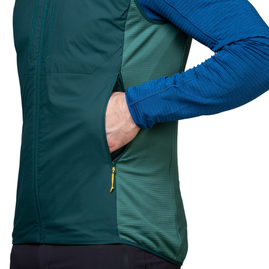 Mountain Equipment Switch Men's Vest in Pine/Fern packed into hand pocket showing lightweight packable construction with twin carabiner carry loops