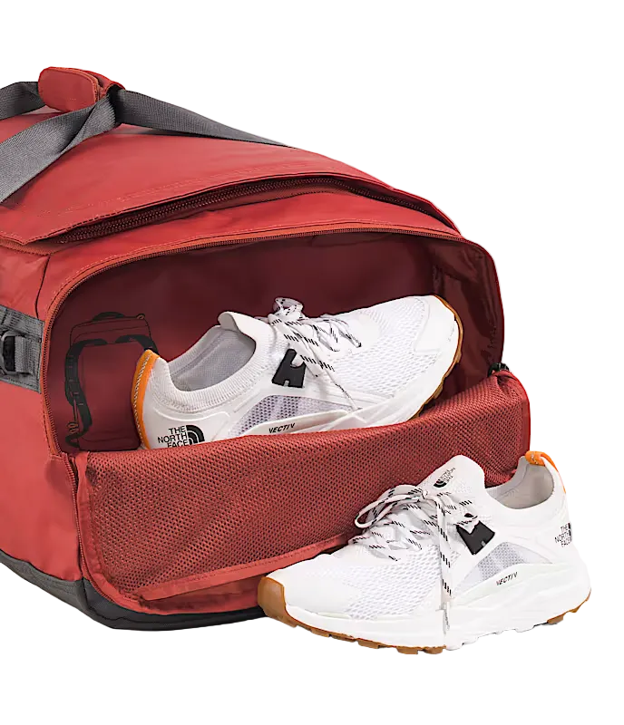 The North Face Base Camp Voyager Duffel 62L Iron Clay/Anthracite Grey/Lava Red - detail of daisy-chain webbing attachment points and recycled ballistic nylon boot construction
