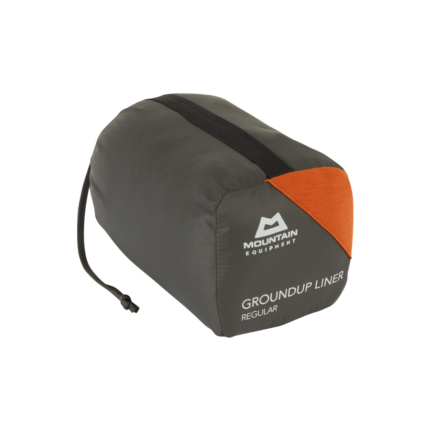 Mountain Equipment Groundup Mummy Sleeping Bag Liner in Paprika in stuff sack showing lightweight packable construction