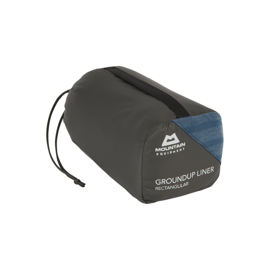 Mountain Equipment Groundup Rectangular Sleeping Bag Liner in Denim Blue in stuff sack showing lightweight packable construction