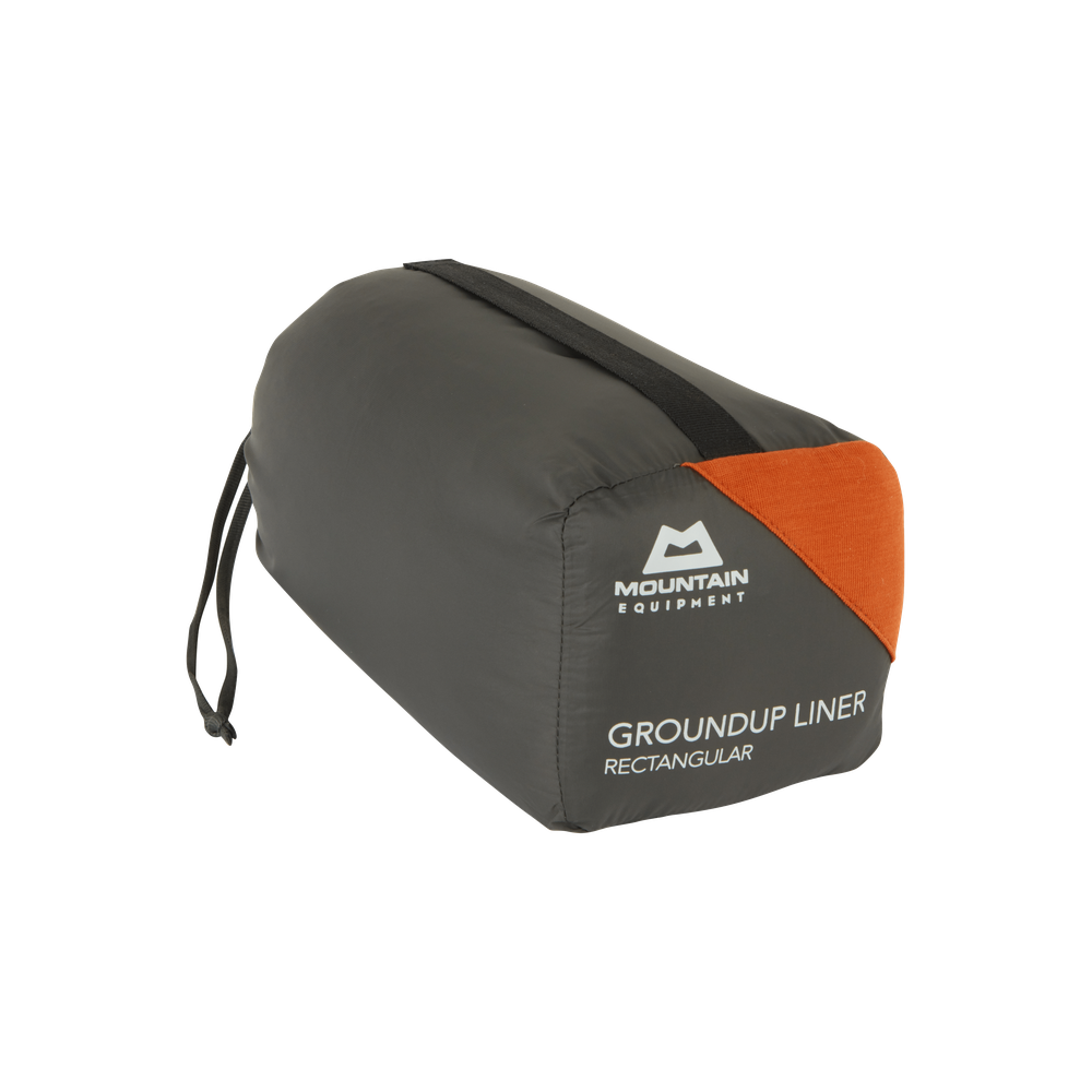 Mountain Equipment Groundup Rectangular Sleeping Bag Liner in Paprika in stuff sack showing lightweight packable construction