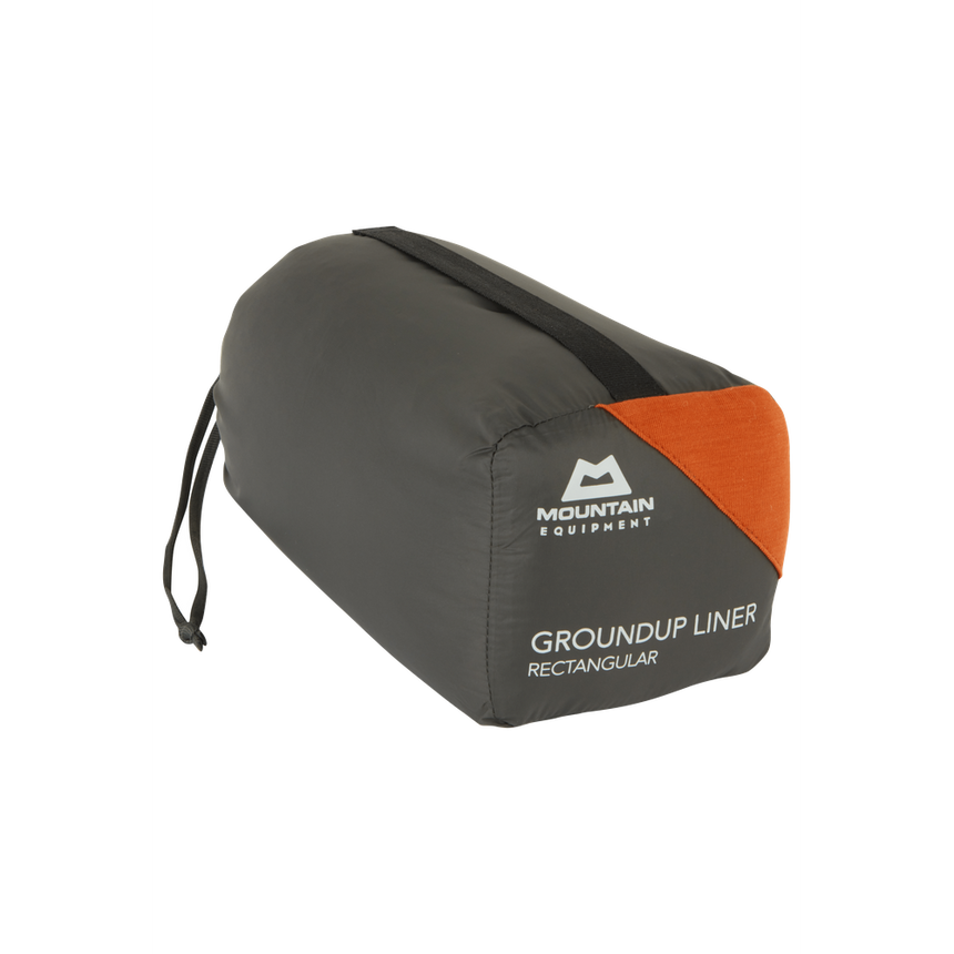 Mountain Equipment Groundup Rectangular Sleeping Bag Liner in Paprika in stuff sack showing lightweight packable construction