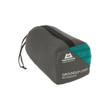 Mountain Equipment Groundup Rectangular Sleeping Bag Liner in Spruce Stripe in stuff sack showing lightweight packable construction